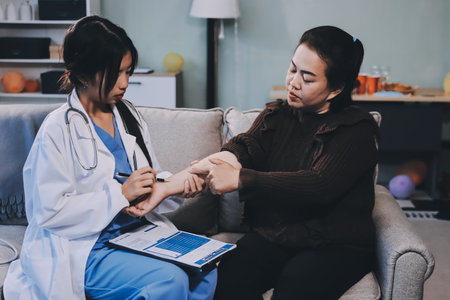 Homecare nursing service and elderly people cardiology healthcare. Close up of young asian female doctor nurse check mature asian woman patient heartbeat using stethoscope during visitの写真素材