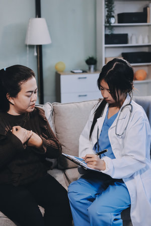 Homecare nursing service and elderly people cardiology healthcare. Close up of young hispanic female doctor nurse check mature caucasian woman patient heartbeat using stethoscope during visitの写真素材