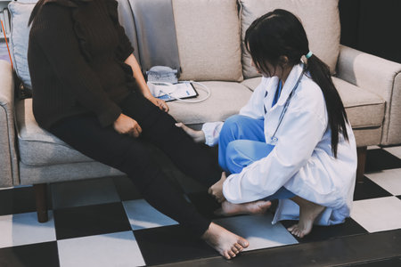 Young doctor examines senior patient's legの写真素材
