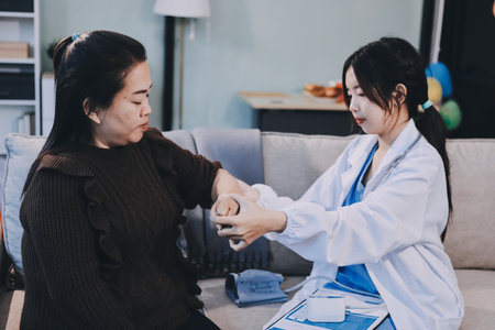 Orthopaedic doctor doing physical examination patient with wrist pain at the clinic. Physical therapist checks the patient wrist by pressing the wrist bone.の写真素材