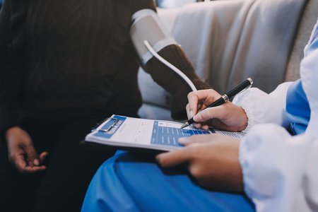 Doctor using Blood pressure monitor and stethoscope checking measuring arterial blood pressure on arm to a patient in the hospital, healthcare and medical conceptの写真素材