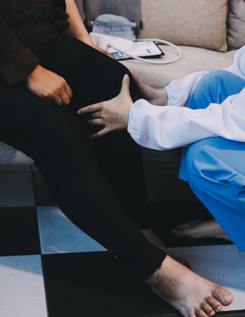 Young doctor examines senior patient's legの写真素材