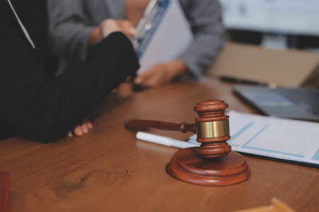 Judge gavel with Justice lawyers having team meeting at law firm background. Concepts of Law and Legal services.の写真素材