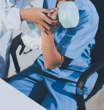 Person using hand weight with support of nurseの写真素材