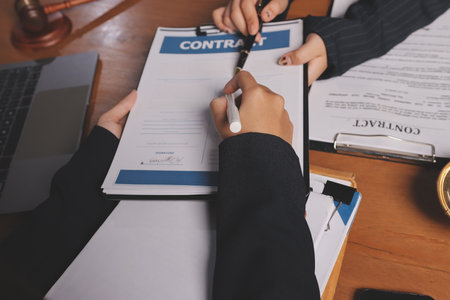 Attractive young lawyer in office Business woman and lawyers discussing contract papers with brass...