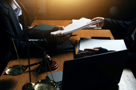 Attractive young lawyer in office Business woman and lawyers discussing contract papers with brass scale on wooden desk in office. Law, legal services, advice, Justice and real estate concept.の写真素材