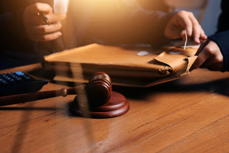 Attractive young lawyer in office Business woman and lawyers discussing contract papers with brass scale on wooden desk in office. Law, legal services, advice, Justice and real estate concept.の写真素材
