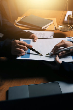 Attractive young lawyer in office Business woman and lawyers discussing contract papers with brass scale on wooden desk in office. Law, legal services, advice, Justice and real estate concept.の写真素材
