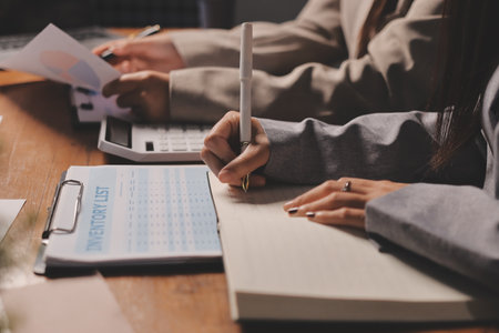 Group of confident business people point to graphs and charts to analyze market data, balance sheet, account, net profit to plan new sales strategies to increase production capacity.の写真素材