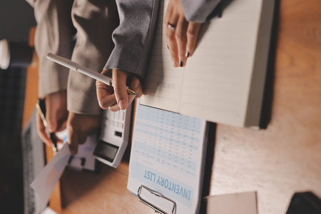 Group of confident business people point to graphs and charts to analyze market data, balance sheet, account, net profit to plan new sales strategies to increase production capacity.の写真素材