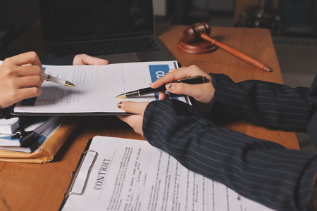 Attractive young lawyer in office Business woman and lawyers discussing contract papers with brass scale on wooden desk in office. Law, legal services, advice, Justice and real estate concept.の写真素材