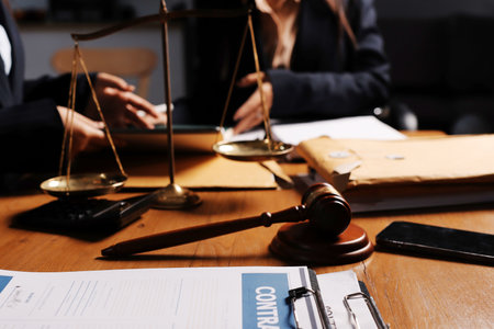 Attractive young lawyer in office Business woman and lawyers discussing contract papers with brass scale on wooden desk in office. Law, legal services, advice, Justice and real estate concept.の写真素材