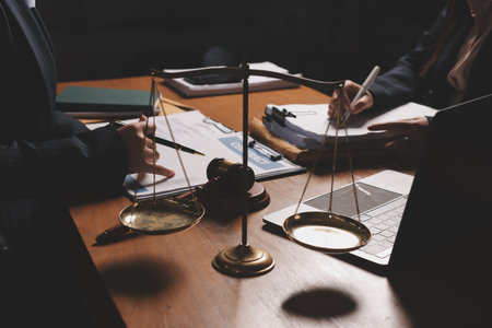 Attractive young lawyer in office Business woman and lawyers discussing contract papers with brass scale on wooden desk in office. Law, legal services, advice, Justice and real estate concept.の写真素材