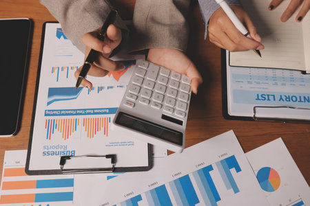 Group of confident business people point to graphs and charts to analyze market data, balance sheet, account, net profit to plan new sales strategies to increase production capacity.の写真素材