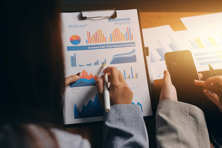 Group of confident business people point to graphs and charts to analyze market data, balance sheet,...