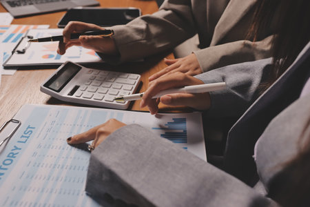 Group of confident business people point to graphs and charts to analyze market data, balance sheet, account, net profit to plan new sales strategies to increase production capacity.の写真素材