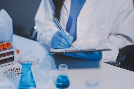 Research, experiment and medical trial being done by a scientist in a lab, science facility or hospital. One young, serious and professional researcher organizing, sorting or making a discoveryの写真素材