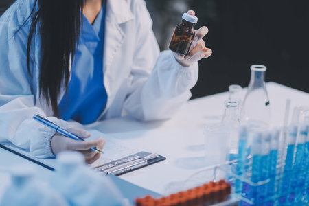 Research, experiment and medical trial being done by a scientist in a lab, science facility or hospital. One young, serious and professional researcher organizing, sorting or making a discoveryの写真素材