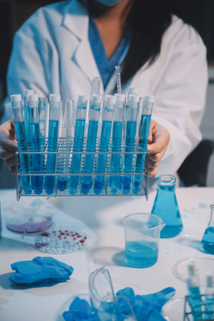 Research, experiment and medical trial being done by a scientist in a lab, science facility or hospital. One young, serious and professional researcher organizing, sorting or making a discoveryの写真素材