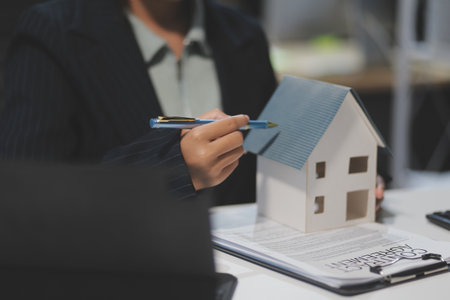 Real estate agents explain models of housing estates in projects to elaborate to clients, explaining and presenting information about homes and purchasing loans. Real estate trading concept.の写真素材