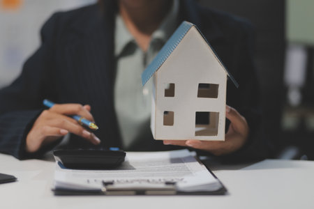 Real estate agents explain models of housing estates in projects to elaborate to clients, explaining and presenting information about homes and purchasing loans. Real estate trading concept.の写真素材