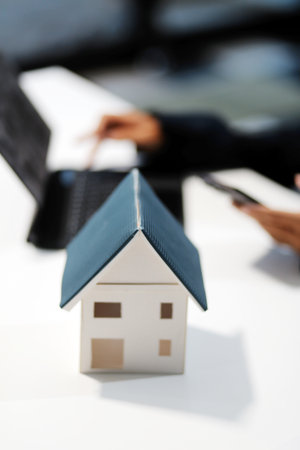 Real estate agents explain models of housing estates in projects to elaborate to clients, explaining and presenting information about homes and purchasing loans. Real estate trading concept.の写真素材