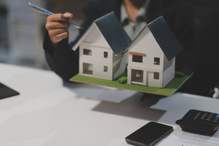 Real estate agents explain models of housing estates in projects to elaborate to clients, explaining and presenting information about homes and purchasing loans. Real estate trading concept.の写真素材