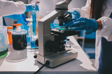 Scientist pipetting medical samples into microplate in laboratoryの写真素材