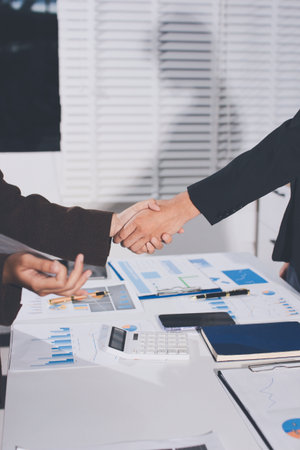 Two businessmen shaking hands after reaching agreement in officeの写真素材