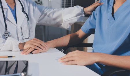 Doctor came to check the patient and shook his hand to encourage. Comforting the sick and treating the best, cured in the hospital.の写真素材