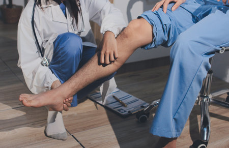 Physical therapist teaching a patient how to do exercises for his knee painの写真素材