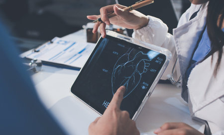 Cropped shot of an unrecognisable doctor sitting with his patient and showing her x-rays on a digital tabletの写真素材
