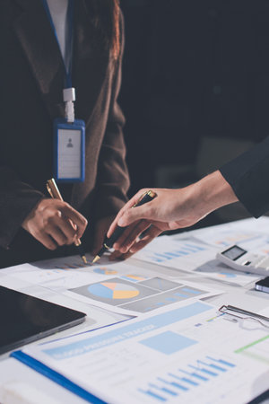Focused young businessman signing agreement with skilled lawyer in eyeglasses. Concentrated financial advisor showing place for signature on paper contract document to male client at meeting in officeの写真素材