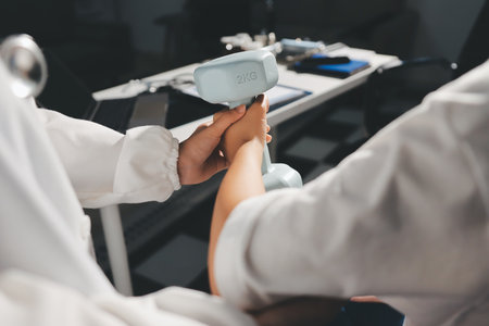 Unrecognizable uses blue hand weight during physical therapy sessionの写真素材
