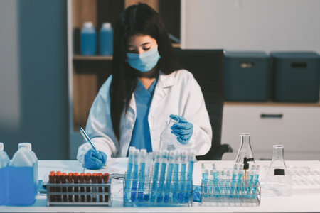 Research, experiment and medical trial being done by a scientist in a lab, science facility or hospital. One young, serious and professional researcher organizing, sorting or making a discoveryの写真素材