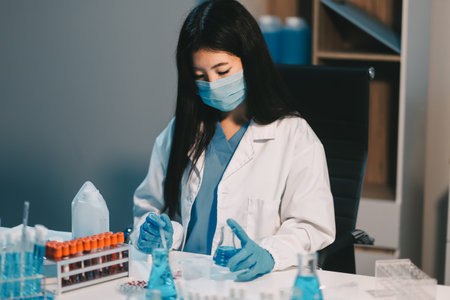 Research, experiment and medical trial being done by a scientist in a lab, science facility or hospital. One young, serious and professional researcher organizing, sorting or making a discoveryの写真素材