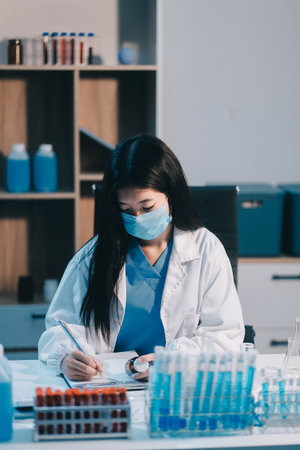 Research, experiment and medical trial being done by a scientist in a lab, science facility or hospital. One young, serious and professional researcher organizing, sorting or making a discoveryの写真素材