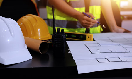 Closeup of team of industrial engineers meeting analyze machinery blueprints consult project on table in manufacturing factory. Working in manufacturing plant or production plant.の写真素材