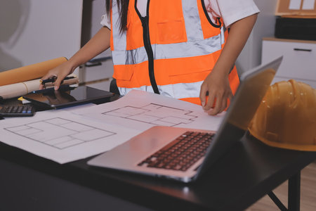 Closeup of team of industrial engineers meeting analyze machinery blueprints consult project on table in manufacturing factory. Working in manufacturing plant or production plant.の写真素材