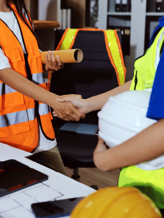Closeup of team of industrial engineers meeting analyze machinery blueprints consult project on table in manufacturing factory. Working in manufacturing plant or production plant.の写真素材