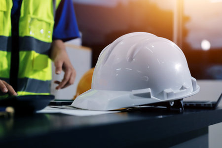Closeup of team of industrial engineers meeting analyze machinery blueprints consult project on table in manufacturing factory. Working in manufacturing plant or production plant.の写真素材