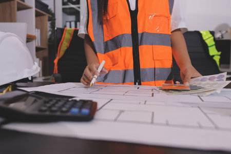 Closeup of team of industrial engineers meeting analyze machinery blueprints consult project on table in manufacturing factory. Working in manufacturing plant or production plant.の写真素材