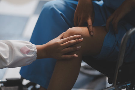 A female doctor examines an elderly patient with knee pain due to arthritis. The patient is being assisted in recovery, focusing on pain management and improving mobility.の写真素材