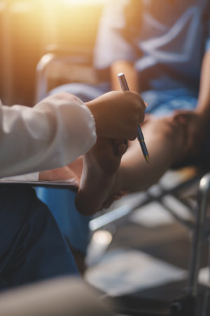 A female doctor examines an elderly patient with knee pain due to arthritis. The patient is being assisted in recovery, focusing on pain management and improving mobility.の写真素材