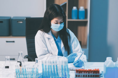 Research, experiment and medical trial being done by a scientist in a lab, science facility or hospital. One young, serious and professional researcher organizing, sorting or making a discoveryの写真素材