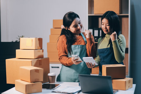 Startup SME small business entrepreneur of freelance Asian woman wearing apron using laptop and box...