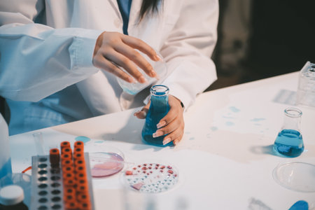 Research, experiment and medical trial being done by a scientist in a lab, science facility or hospital. One young, serious and professional researcher organizing, sorting or making a discoveryの写真素材
