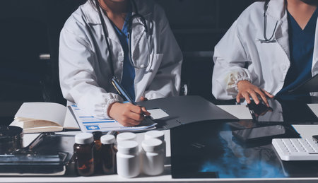 Male and female doctors are having a meeting in a hospital room.の写真素材