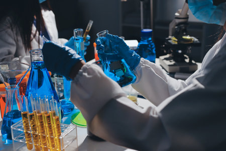 Scientist pipetting medical samples into microplate in laboratory