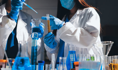 Scientist pipetting medical samples into microplate in laboratoryの写真素材